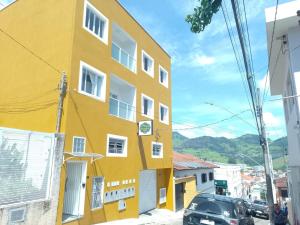 a yellow building on the side of a street at Verissimu's Pousada in Paraisópolis