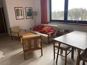 a living room with a couch and a table and chairs at Dachstein Panorama-Lodge in Bad Goisern