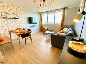 ein Wohnzimmer mit einem Sofa und einem Tisch in der Unterkunft Amateru - SILS in Caen