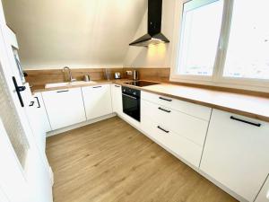 a kitchen with white cabinets and a sink and a window at Amateru - SILS in Caen