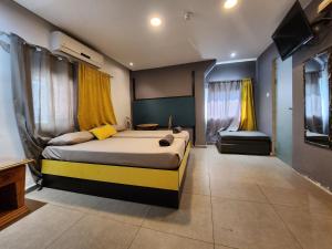 a bedroom with a large bed with yellow curtains at Amdar Hostel in Eilat