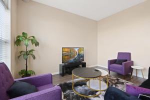 a living room with purple couches and a tv at Cozy Indy Get Away - Private Room - Shared in Indianapolis