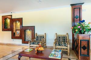 a living room with two chairs and a table at OYO Hotel Shenandoah Woodlands Mall in The Woodlands