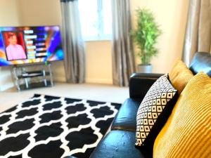 sala de estar con sofá azul y alfombra blanca y negra en Amazing 2-Bed City Centre Apt with Parking, en Spon End