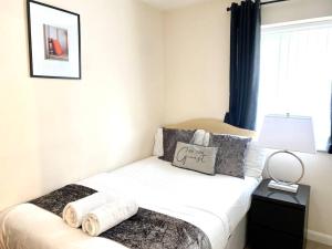 a bedroom with a bed with towels on it at Amazing 2-Bed City Centre Apt with Parking in Spon End