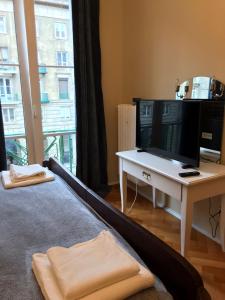 a bedroom with a bed and a desk with a tv at Stylowy apartament w centrum in Wrocław