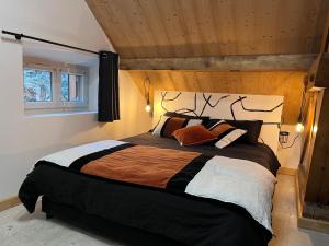 a bedroom with a large bed with a wooden ceiling at Refuges sous les toits in Bourg-Saint-Maurice