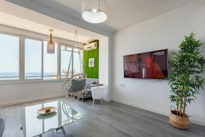 ein Wohnzimmer mit einem TV an der Wand in der Unterkunft Estudio con increíbles vistas a la Playa + Piscina in Aguadulce