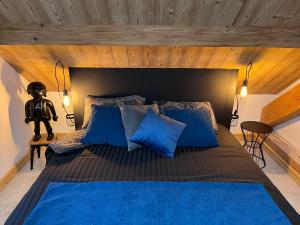 a bedroom with a large bed with blue pillows at Refuges sous les toits in Bourg-Saint-Maurice