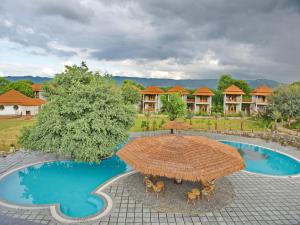 an umbrella and chairs in front of a resort pool at Wild Rose Resort and Spa in Pushkar