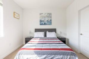 Affordable 1BD, Comfy Queen Beds, with GYM في انديانابوليس: غرفة نوم مع سرير وبطانية حمراء بيضاء وزرقاء