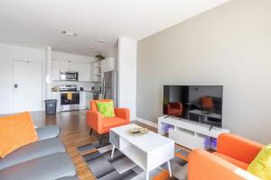 sala de estar con sillas de color naranja y mesa blanca en Affordable 1BD, Comfy Queen Beds, with GYM en Indianápolis
