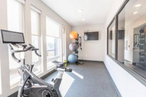 a gym with a bike in a room with windows at Affordable 1BD, Comfy Queen Beds, with GYM in Indianapolis