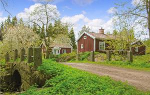 VimmerbyにあるGorgeous Home In Vimmerby With Kitchenの家屋と赤い家の未舗装路