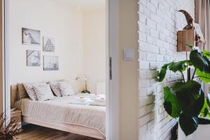 a bedroom with a bed and a brick wall at Apartament Niko in Toruń