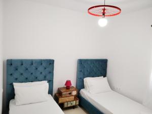 1 dormitorio con 2 camas y lámpara roja en Alkyonis house en Triovasálos