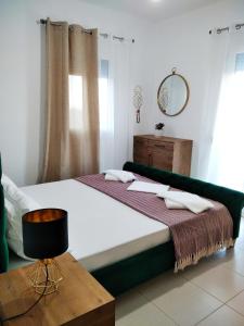 1 dormitorio con 1 cama grande y espejo en Alkyonis house en Triovasálos