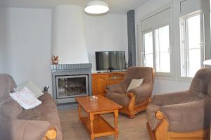 a living room with two chairs and a fireplace at Casa Mar i Sol in L'Ampolla