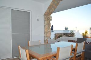 a dining room with a glass table and chairs at Casa Mar i Sol in L'Ampolla