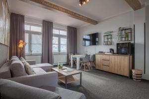 ein Wohnzimmer mit einem Sofa und einem Tisch in der Unterkunft AKZENT Strandhotels Seestern, Delphin & Lachs in Wilhelmshaven