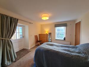 1 dormitorio con cama y ventana en Old Police Station, Portsoy, en Portsoy