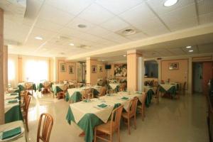 a restaurant with tables and chairs with green tablecloths at Albergo Villa Ada in Borgio Verezzi