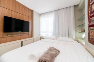 1 dormitorio con 1 cama blanca y TV de pantalla plana en Excelente flat em Setúbal Boa Viagem até 4 pessoas cercado por restaurantes e supermercados PM805, en Recife
