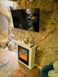 Una chimenea en una habitación con una pared de piedra. en La Ruta - La Cueva, en Confrides