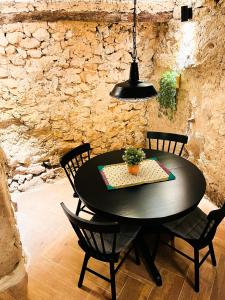 una mesa de comedor negra con sillas y luz eólica en La Ruta - La Cueva, en Confrides