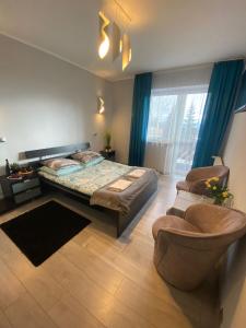 um quarto com uma cama, um sofá e uma cadeira em Hotel Restauracja U Guta em Klikuszowa