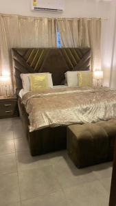 1 cama grande en un dormitorio con 2 lámparas en Accra Luxury apartments at Oasis Park Residences, en Accra