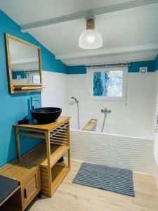 uma casa de banho com um lavatório e uma banheira em Maison + piscine à 10 min d'Aix en Pce em Meyreuil