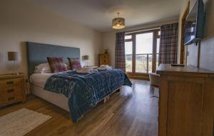 a bedroom with a bed and a desk and a television at Ardbrae in Spean Bridge