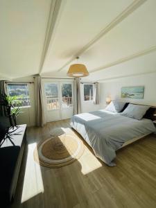 um quarto com uma cama grande e janelas em Maison + piscine à 10 min d'Aix en Pce em Meyreuil