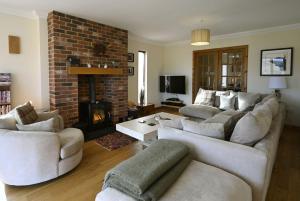 a living room with two couches and a fireplace at Ardbrae in Spean Bridge