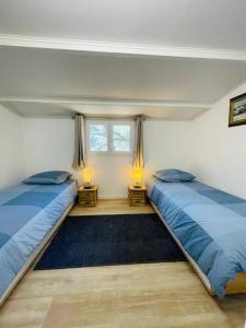duas camas num quarto com duas lâmpadas nas mesas em Maison + piscine à 10 min d'Aix en Pce em Meyreuil