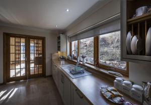 a kitchen with a counter and two windows at Ardbrae in Spean Bridge