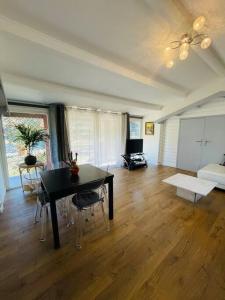 uma sala de estar com uma mesa preta e cadeiras em Maison + piscine à 10 min d'Aix en Pce em Meyreuil