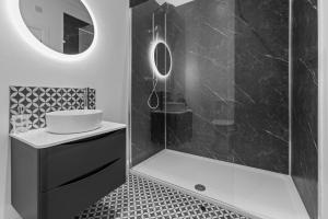 a bathroom with a shower with a sink and a mirror at Stayover Suites in Ballymena