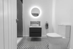 a black and white bathroom with a toilet and a sink at Stayover Suites in Ballymena