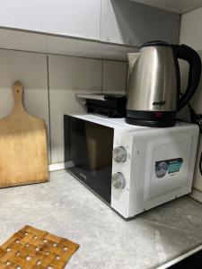a microwave with a coffee pot on top of it at Hardy's Apartment in Belgrade