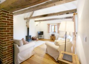 uma sala de estar com mobiliário branco e uma parede de tijolos em Old Root House, Lavant em Chichester