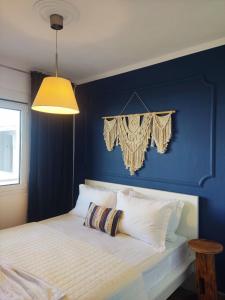 Villa Ulyana Toroni - Front seaview, First line, Fireplace في توروني: غرفة نوم بحائط ازرق مع سرير