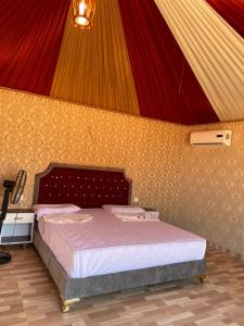 a bedroom with a bed with a colorful wall at Panorama camp jeep trips in Wadi Rum