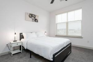 um quarto branco com uma cama grande e uma janela em Lovely Private bedroom - Shared em Whitestown