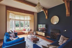 a living room with blue furniture and a fireplace at The Old Vicarage in Holmrook