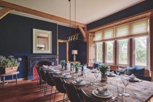 a dining room with a long table and chairs at The Old Vicarage in Holmrook