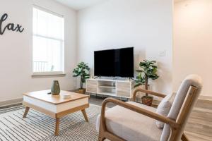 uma sala de estar com uma televisão, uma cadeira e uma mesa em Luxurious 2-Bedroom, Whitestown em Whitestown