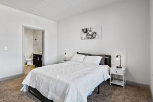 Un dormitorio blanco con una gran cama blanca y una mesa en Luxurious 2-Bedroom, Whitestown, en Whitestown