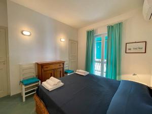 1 dormitorio con 1 cama azul y 2 toallas en Casa di MARI - Appartamento con grande terrazza, en Sperlonga